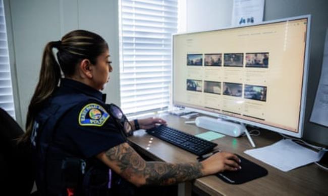 East Palo Alto police officer Wendy Venegas reviews body camera footage and uses Axon’s Draft One AI-based system to draft reports based on the audio from the camera at police headquarters in East Palo Alto on Sept. 23, 2024.