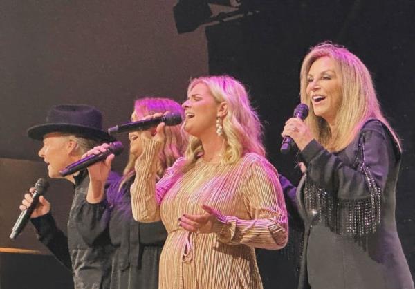 Gospel group The Nelons singing into microphones at a concert